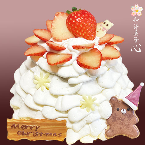 ふりふりに絞った生クリームたっぷりのクリスマスケーキの画像。大粒の苺がのって、くまのアイシングクッキーが可愛さをプラスしている。